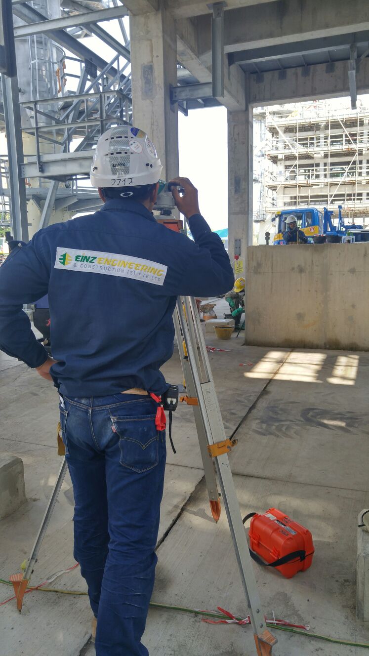 Surveyor using an optical level for foundation checks